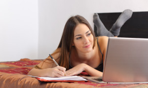 Teenager student studying with a laptop in her room